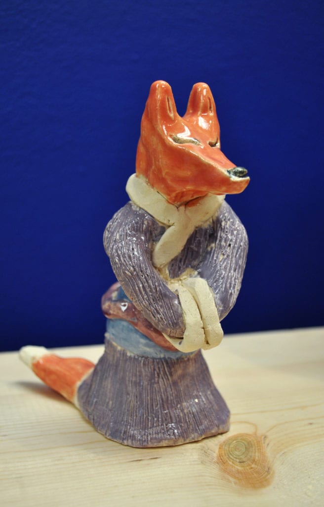 This is a ceramic sculpture by Katie Mendoza, an artist, educator and curator. According to her bio: Katie creates and designs characters and stories for movies. She recently designed and made a set of tarot cards and does readings. Her paintings, drawings and sculpture generally have a surprise element to draw the viewer in.