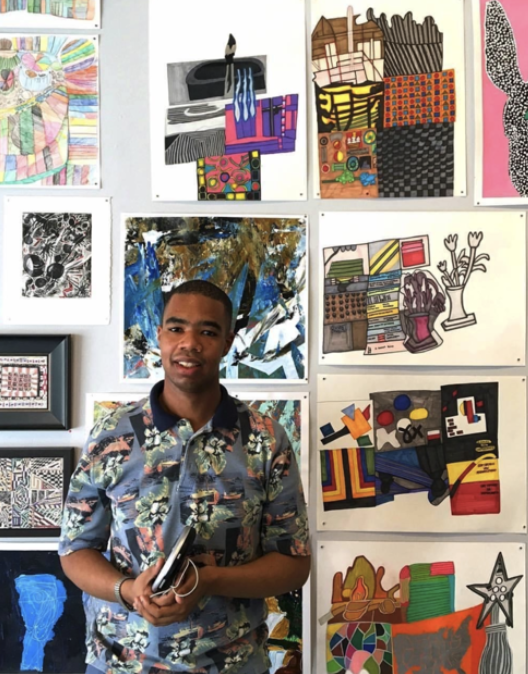 The image is a photograph of a man standing in front of 11 artworks. He is wearing a colorful patterned shirt with a black collar. (provided by Tierra and the artist